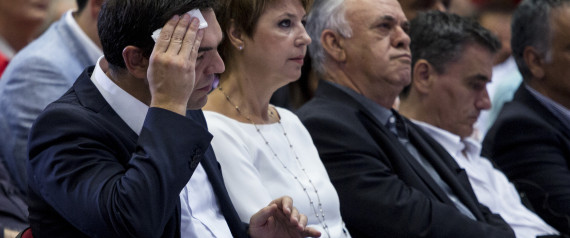 Alexis Tsipras, former Greek prime minister and leader of the Syriza party, left, wipes his brow as he sits at the Thessaloniki International Trade Fair in Thessaloniki, Greece, on Sunday, Sept. 6, 2015. Greek voters are getting ready to cast their ballots after Tsipras