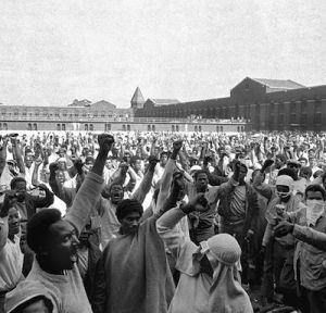 FILE - This Sept. 10, 1971 file photo shows inmates of Attica State Prison as they raise their hands in clenched fist salutes to voice their demands during a negotiating session with New York